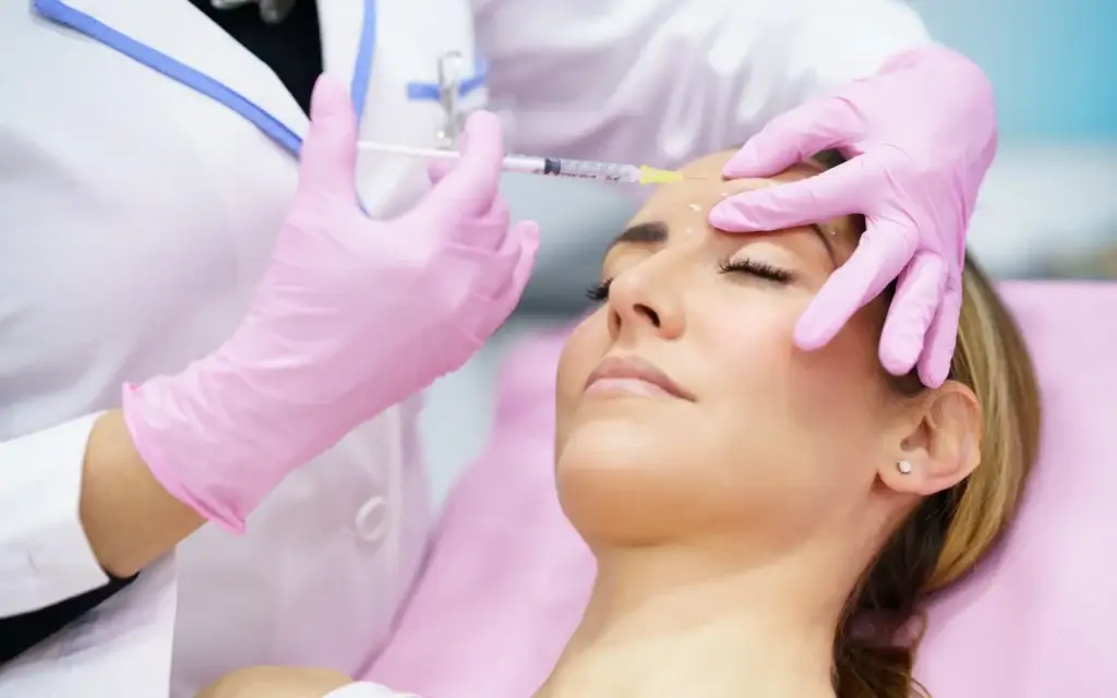 Close-up of a woman receiving a Botox injection on her forehead